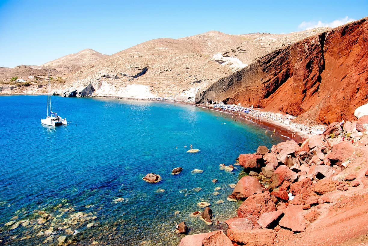 Santorini's distinctive Red Beach with volcanic red cliffs